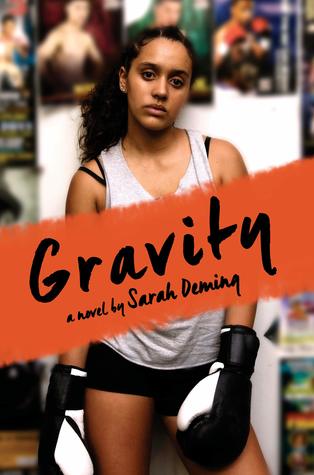 Book cover for Gravity. A young woman with black curly hair pulled back into braids at the top and a dark complexion stares into the camera. She wears a white tank top, black shorts, and black and white boxing gloves. The wall behind her is covered in martial artist posters. 